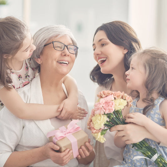 a photo of a mom, two children and a grandmother all hugging. 