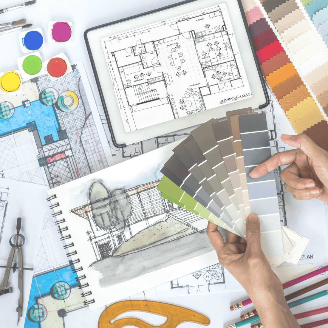 desk with water colors and paint swatches and floor plans 