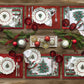 Set of 4 placemats with a white holly damask design on background, a christmas tree in the center and a holly and red ribbon border. The backside is also reversible with a solid red color and holly damask design on a tablescape