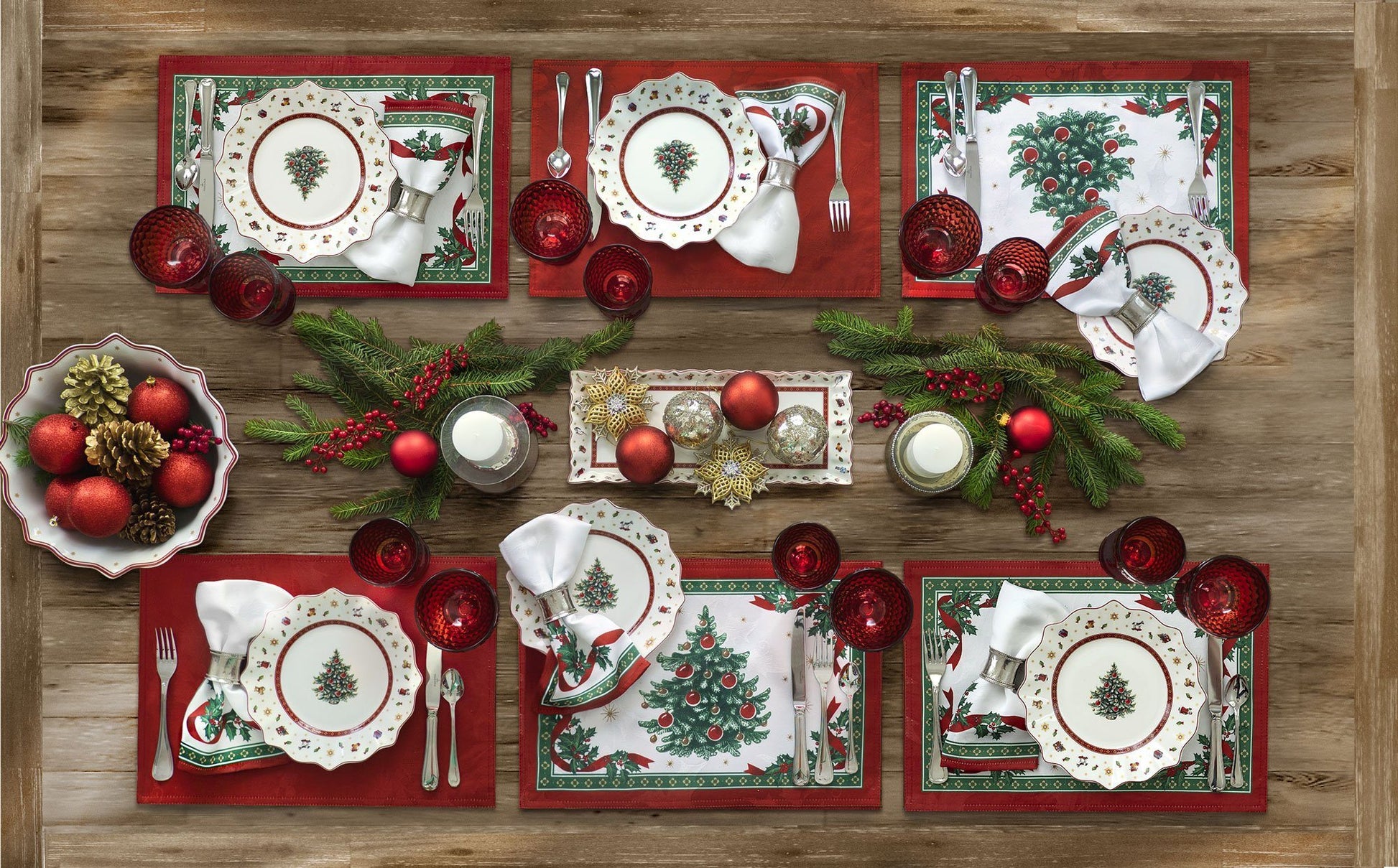 Set of 4 placemats with a white holly damask design on background, a christmas tree in the center and a holly and red ribbon border. The backside is also reversible with a solid red color and holly damask design on a tablescape